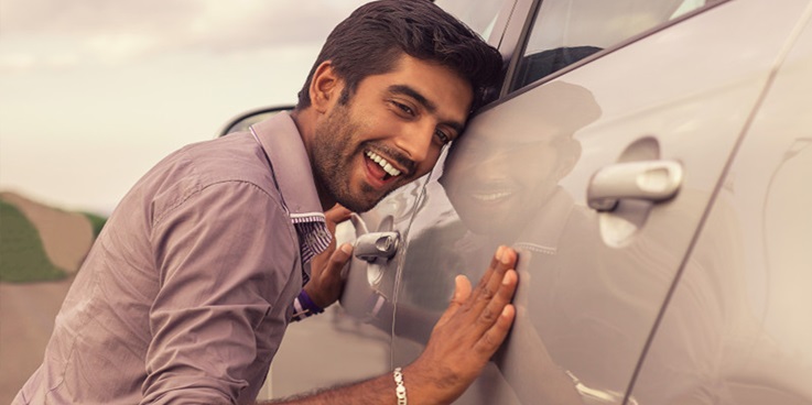 Ein Mann streichelt zärtlich über die Karosserie seines Fahrzeuges