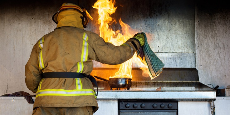 Feuerwehrmann löscht Brand in Küche